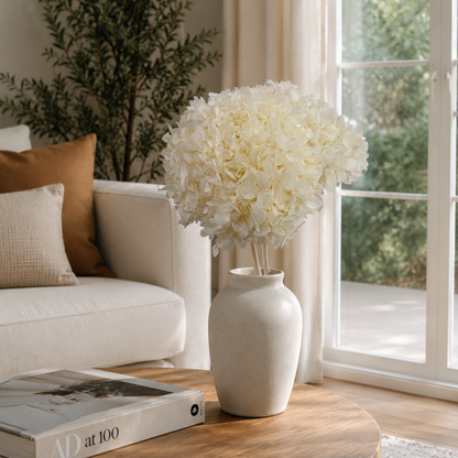 Natural ivory preserved hydrangea stems styled in a vase on a coffee table
