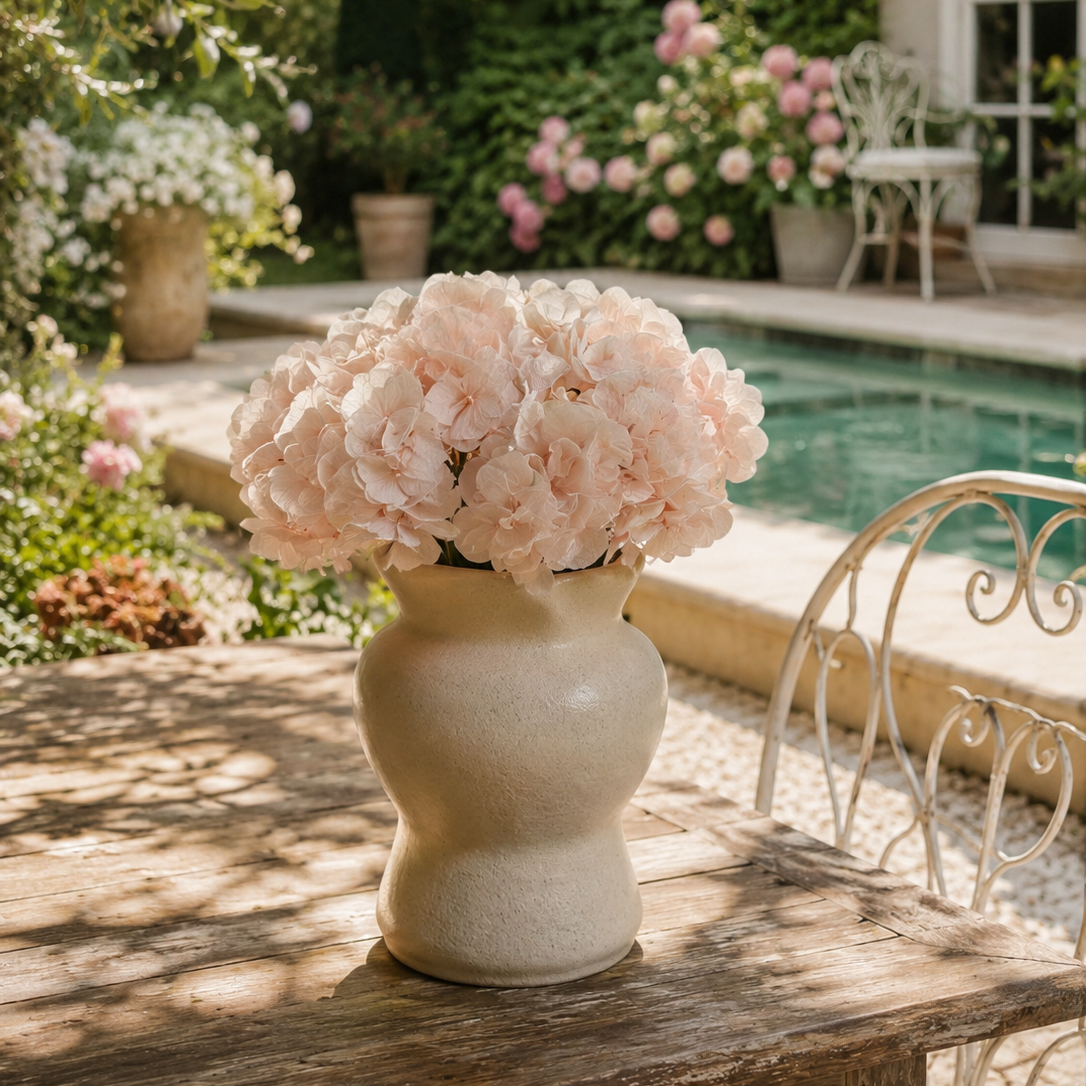 Blush pink preserved hydrangea stems styled in a vase on a coffee table
