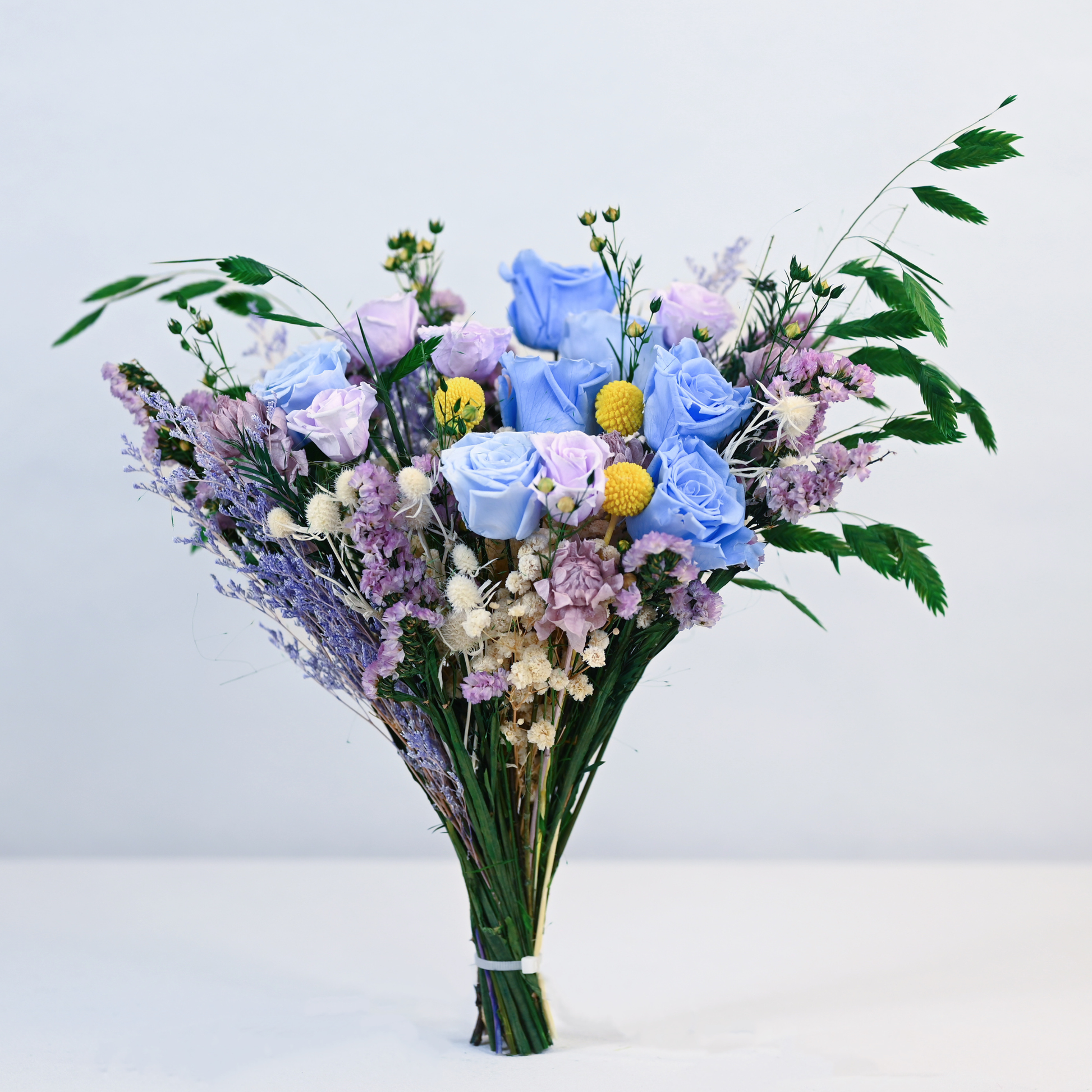 Moonstone Garden Preserved Flower Bouquet hand-tied arrangement of blue and lavender roses, statice, and baby's breath without vase