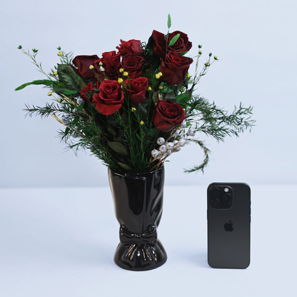 Velvet Rouge Preserved Rose Bouquet in a cream ceramic bow vase next to an iPhone for size reference