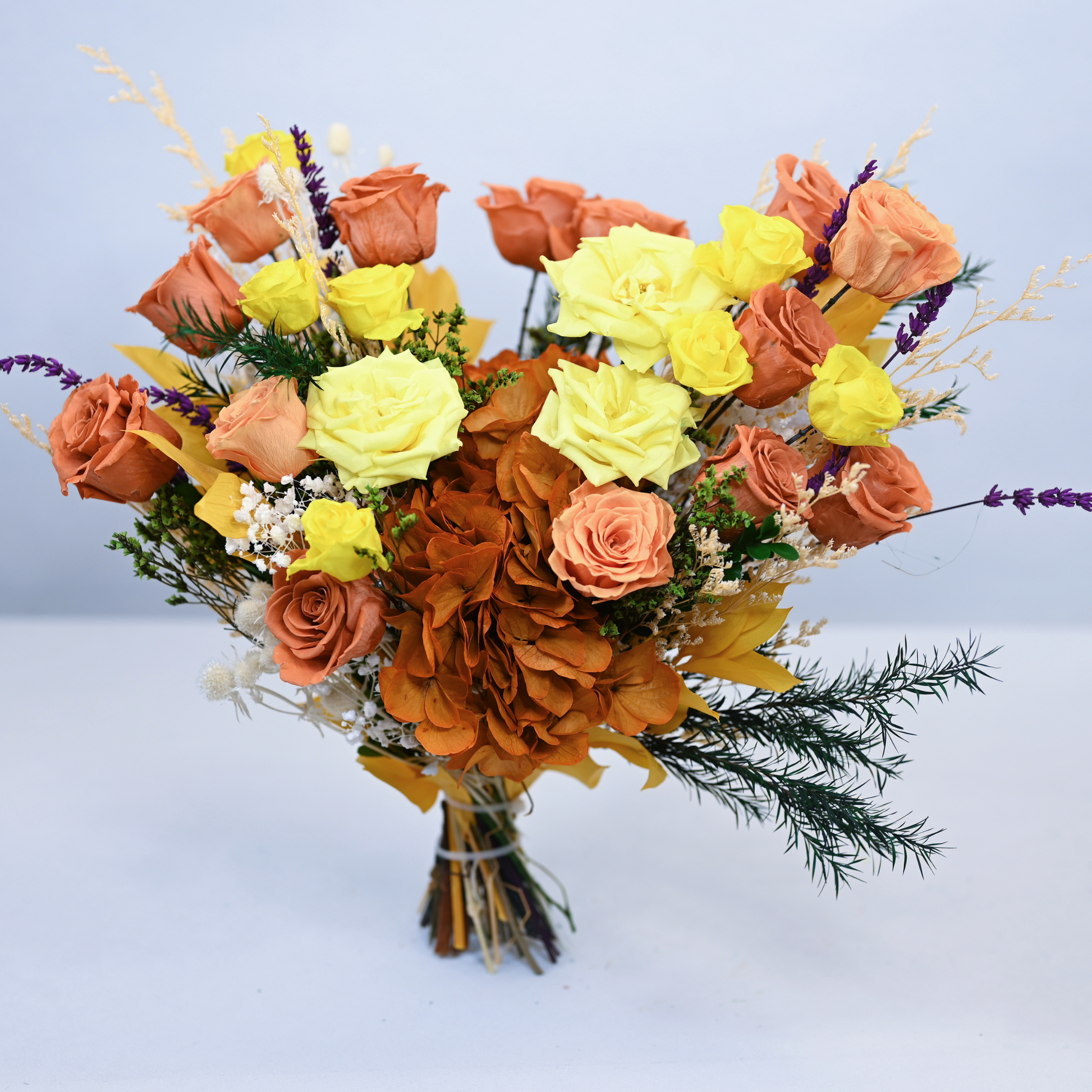 Golden Hour Preserved Flower Bouquet standing upright showing full arrangement of orange, peach and yellow roses with lavender and asparagus fern, front view