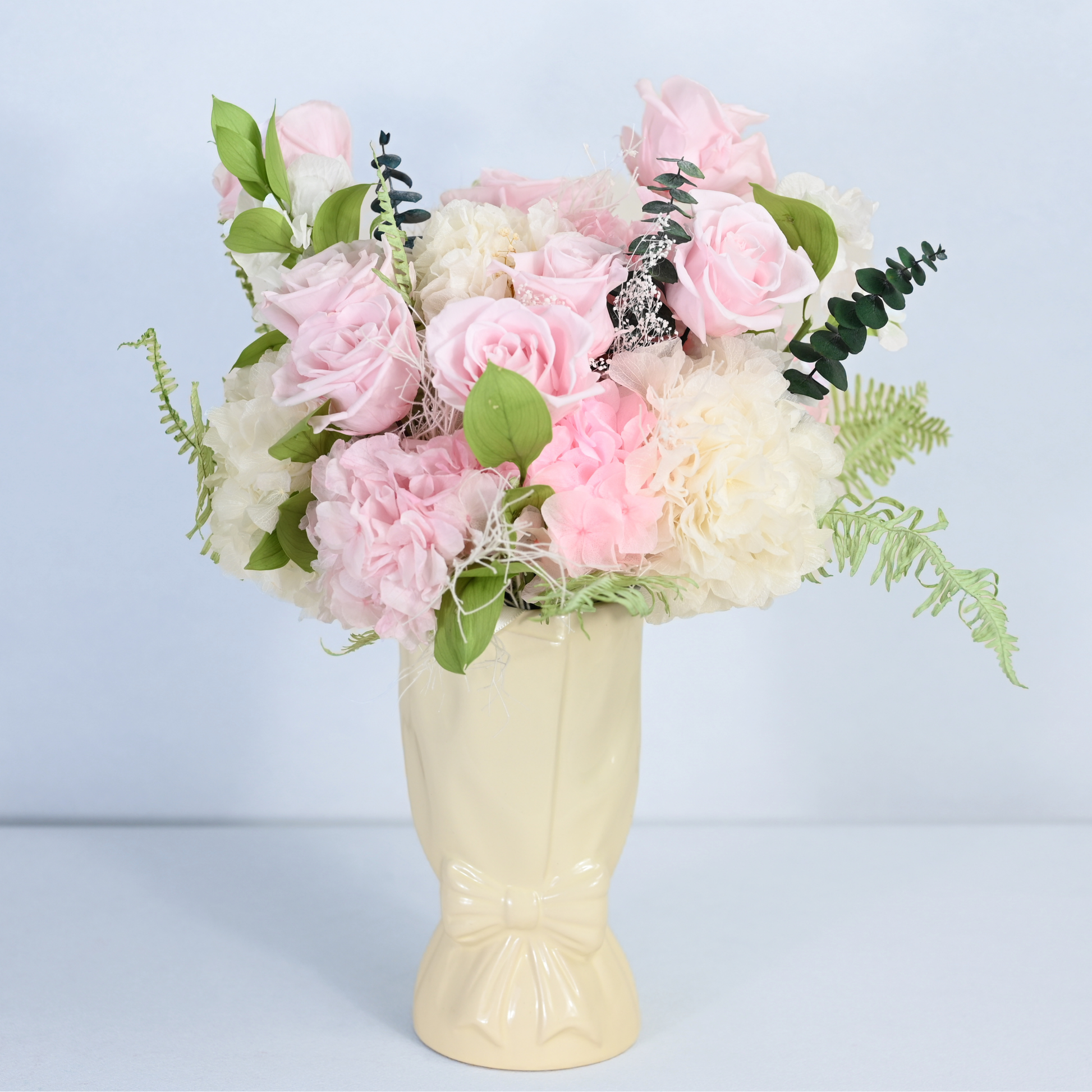Rose Villa Preserved Flower Bouquet displayed in a cream ceramic bow vase, front view