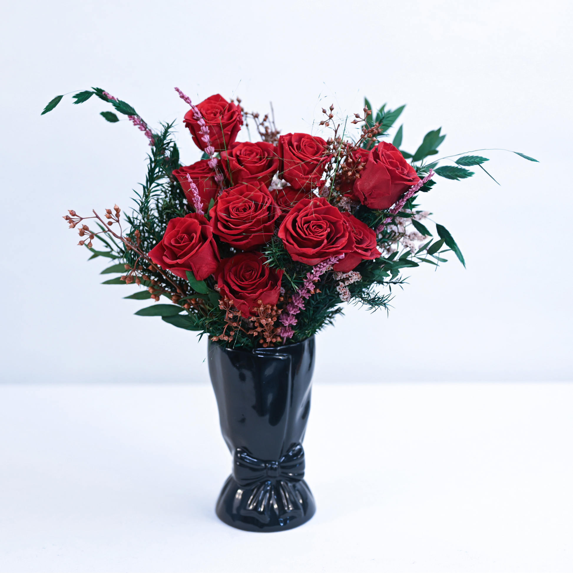 Ruby Romance Preserved Rose Bouquet with red roses, pink lavender, and eucalyptus displayed in a black ceramic bow vase