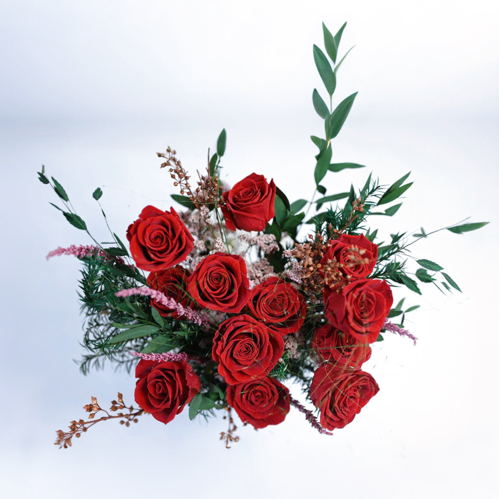 Aerial view of the Ruby Romance Preserved Rose Bouquet showing red roses, crystal grass, and hypericum berry accents