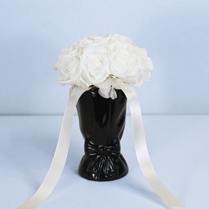 Opal Preserved Rose Bouquet displayed in a black ceramic bow vase with flowing cream satin ribbon, front view