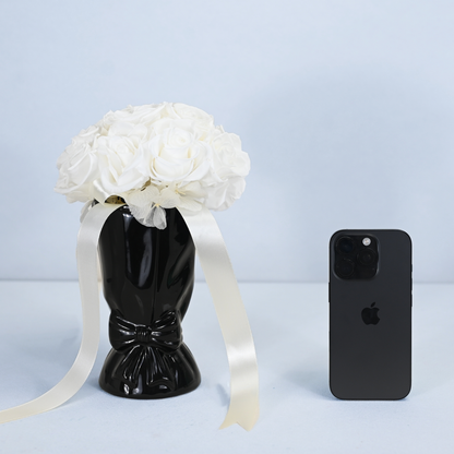 Opal Preserved Rose Bouquet in black ceramic bow vase shown next to an iPhone for size reference