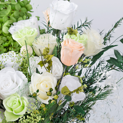 Close-up side view of Opal Bloom Preserved Flower Bouquet featuring white and peach roses, green hydrangea, gossamer grass and eucalyptus