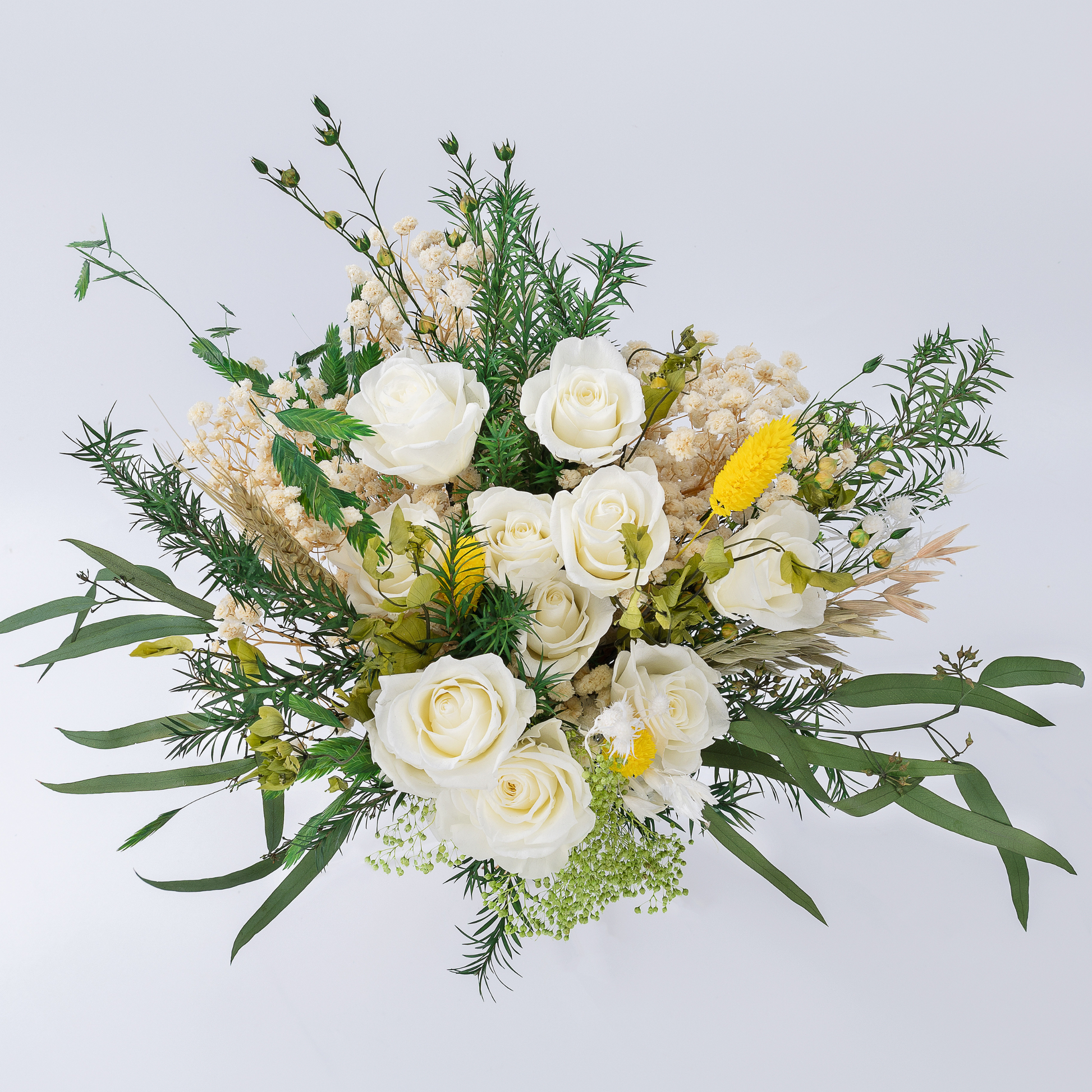 Aerial view of Opal Meadow Preserved Flower Bouquet showing white roses, yellow craspedia, baby's breath and mixed green botanicals
